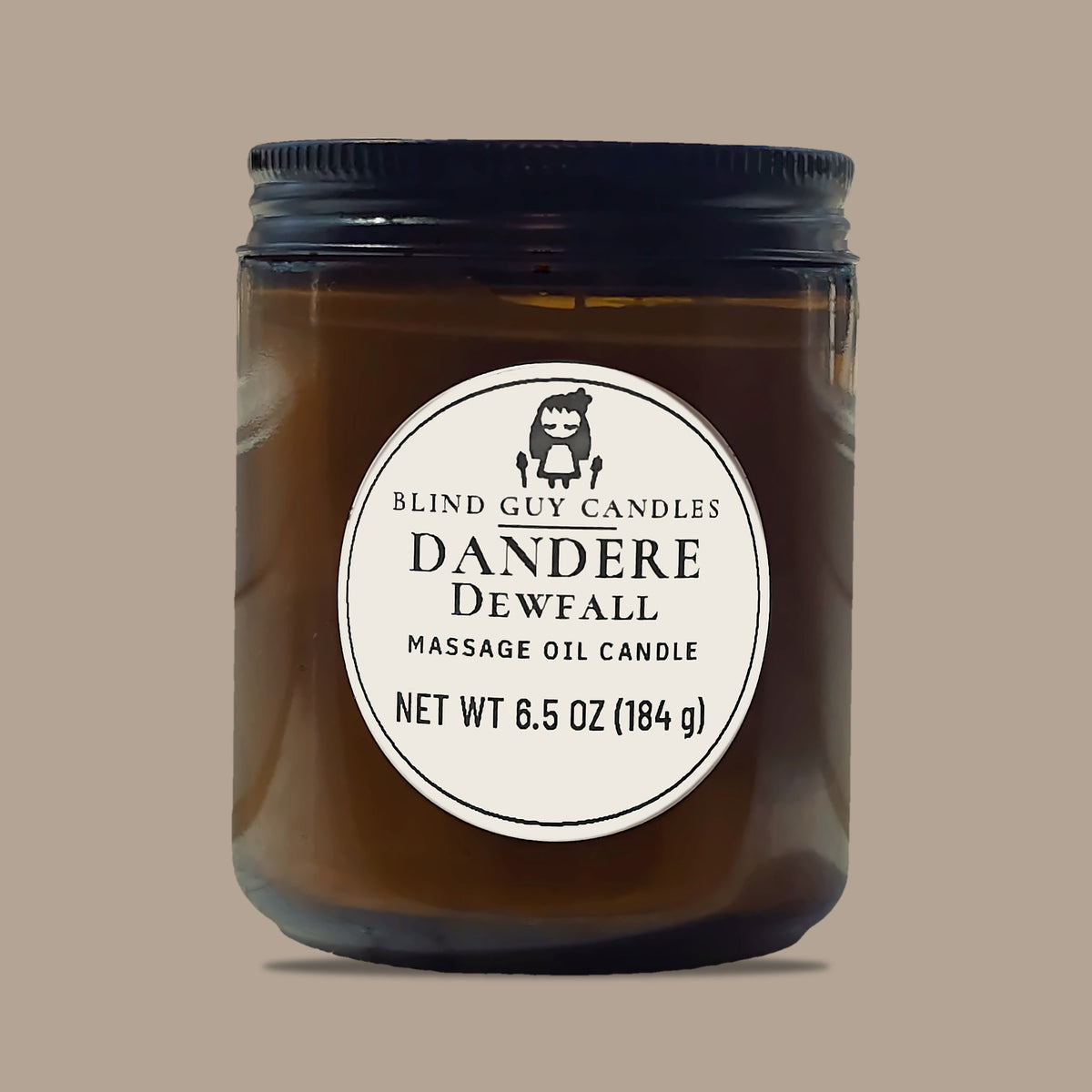 Dandere Dewfall massage oil candle, amber glass jar with black lid, on a plain light background