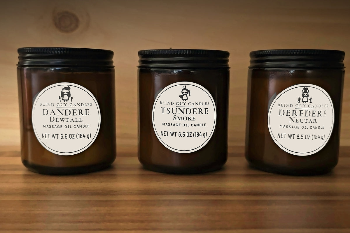 Dandere Dewfall, Tsundere Smoke and Deredere Nectar candles side by side on warm wood