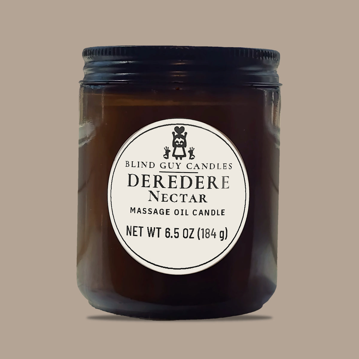 Deredere Nectar massage oil candle, amber glass jar with black lid, on a plain light background